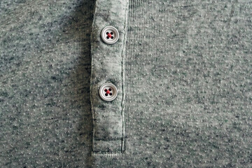 A gray shirt with a button on the front
