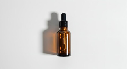 Fototapeta premium Minimalist Amber Glass Dropper Bottle with Long Shadow on White Background. Empty Brown Serum Bottle for Skincare, Essential Oils, or Cosmetic Prod...