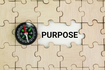 Wooden puzzle and compass with Purpose. the reason for which something is done or created or for...