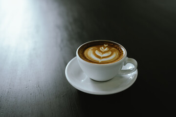 Close-up shot of a creamy latte in a white ceramic mug, evoking the warmth, comfort, relaxation and quiet enjoyment of a quiet and mindful coffee break.