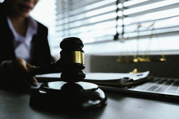 A symbolic image of justice and law, featuring a gavel, scales, and a laptop, representing legal...