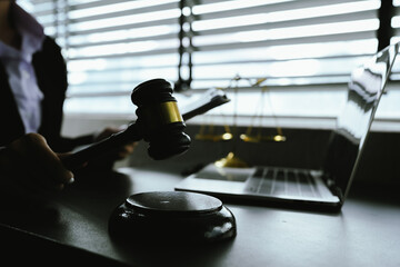 A symbolic image of justice and law, featuring a gavel, scales, and a laptop, representing legal...