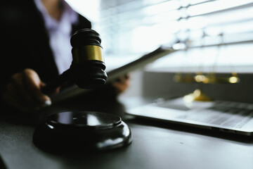 A symbolic image of justice and law, featuring a gavel, scales, and a laptop, representing legal...
