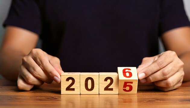 Transitioning from 2025 to 2026 a person s hands adjust wooden blocks displaying the changing years