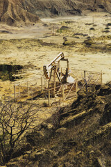 A barren desert with a large oil rig in the middle