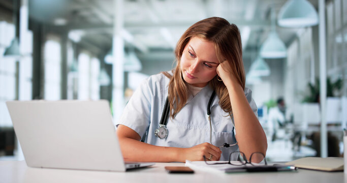 Exhausted Pharmacist Consults Computer At Hospital Amidst Worry And Stress
