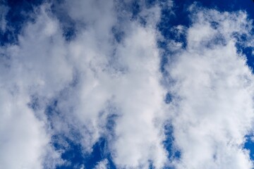 A tranquil cloudscape showcasing fluffy white cumulus clouds in a vivid blue sky. This serene scene...