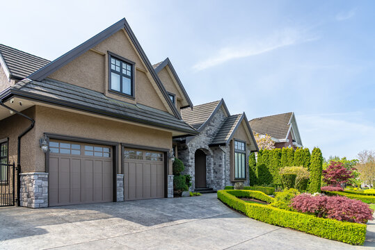 Garage door in luxury house with trees and nice landscape in Spring in Vancouver, Canada, North America. Day time on May 2025.