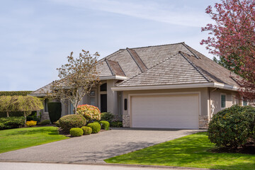 Garage door in luxury house with trees and nice landscape in Spring in Vancouver, Canada, North...