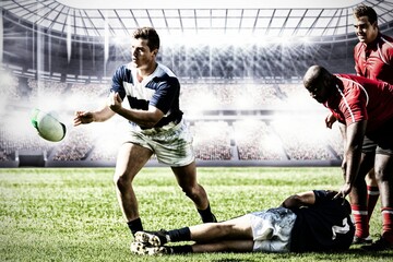 Rugby player jumping with the ball in sports stadium