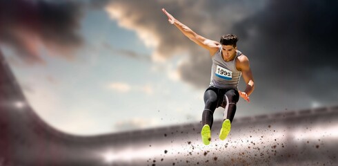 Low angle view of concentrated male athlete long jumping