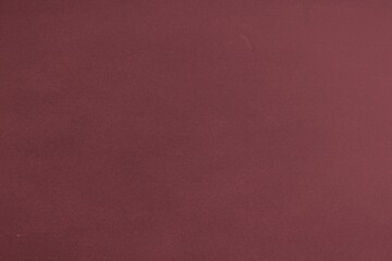 Fototapeta premium Maroon textured surface covering entire frame in flat design, suggesting fabric backdrop