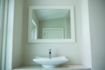 Wash bowl by mirror hanging on wall in bathroom