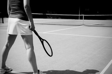 Low section of woman standing with racket