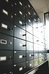 Grid of black safety deposit boxes is appearing in flat design vault scene, featuring inserted keys