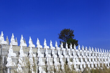 White Buddha statues are beautifully arranged in rows.
