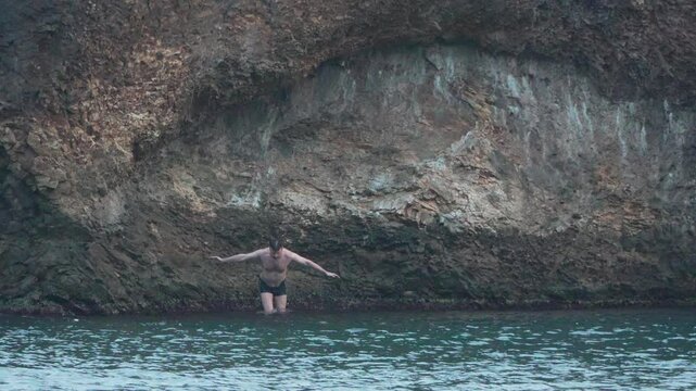 Woman Cliff Jumping Water Cave