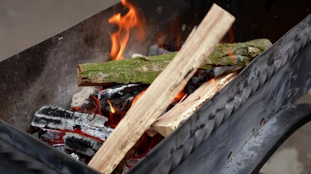 Burning woods in barbecue grill outdoors during summertime. Preparing smoked grilled American traditional bbq food. Family time holidays activities