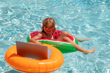 Kids working with laptop on summer vacation holidays. Little freelancer using computer, remote...