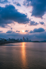 Fototapeta premium A view of the sunset city of Yeouido in the financial district taken on the Dongjak Bridge on the Han River in summer evening 