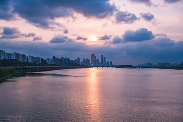 Fototapeta premium A view of the sunset city of Yeouido in the financial district taken on the Dongjak Bridge on the Han River in summer evening 