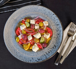 Fresh healthy vegetable Mediterranean salad of tomato, olives, green pepper and green basil leaves, banner, top view