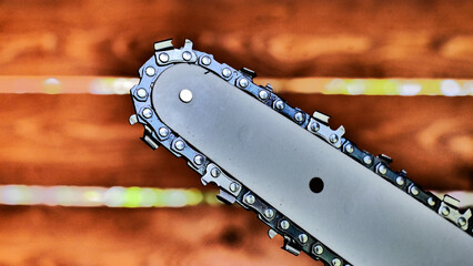 Close-up of a nice black chainsaw against a wooden wall