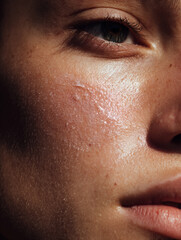 Close up shot of a woman's cheek with a soft smear of skincare cream. Portrait for Skincare product