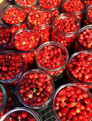 Glass jars of wild strawberries at a local market
