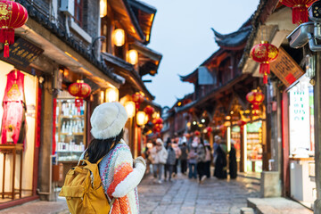 Young female tourists enjoy traveling to Lijiang Ancient Town, the famous tourist destination in Yunnan Province in China
