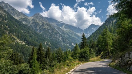Winding road through alpine valley, mountains rise above