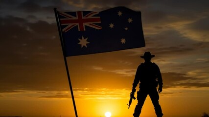 Silhouetted soldier standing beside australian flag at vibrant sunset in open landscape