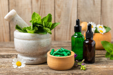 Alternative medicine herbal capsule organic drug on wooden background.Assortment of herbal and...