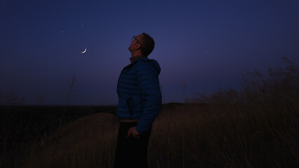 Amateur astronomer watching stars, Moon, planets and other celestial objects from a countryside...