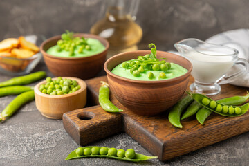 Green pea soup on a wooden table. Fresh pea soup bowl. Delicious healthy cream soup in a bowl with green peas and croutons. Healthy vegan puree. Copy space. Space for text.