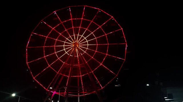 Red Neon Ferris Wheel Spinning at Night &ndash; Amusement Ride with Glowing Lights