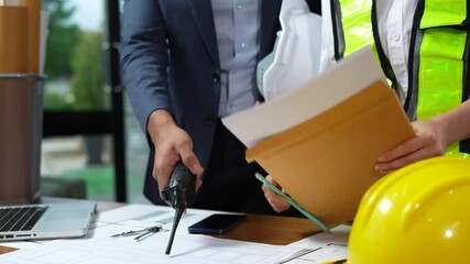 Engineer teams meeting working together wear worker helmets hardhat on construction site. Asian industry professional team.