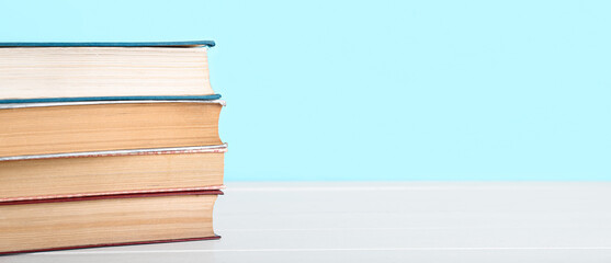 Stack of books on table against blue background