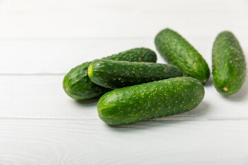 Cucumber on wooden background. Slice of cucumber on background. Fresh organic green cucumbers gherkin. Vegan. Salad ingredient. Farm vegetables. Cut vegetables with knife. Space for text. Copy space