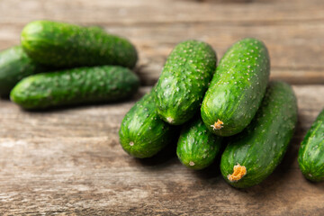 Cucumber on wooden background. Slice of cucumber on background. Fresh organic green cucumbers gherkin. Vegan. Salad ingredient. Farm vegetables. Cut vegetables with knife. Space for text. Copy space