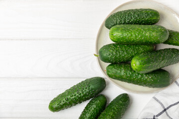 Cucumber on wooden background. Slice of cucumber on background. Fresh organic green cucumbers gherkin. Vegan. Salad ingredient. Farm vegetables. Cut vegetables with knife. Space for text. Copy space