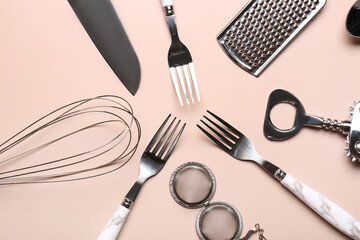 Set of different kitchen utensils on beige background