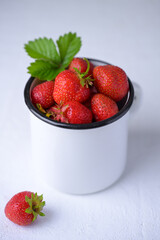 Cup filled with fresh strawberries. Seasonal summer berries, healthy dessert or snack.