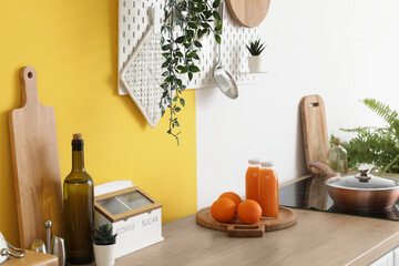 Cutting board with bottles of juice and oranges on wooden countertop in kitchen