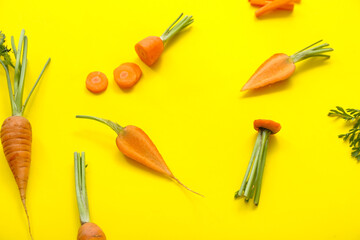 Fresh carrot and slices on yellow background