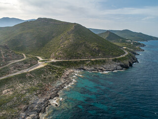 Aerial view car Roadtrip Winding road along rocky coast of Cap Corse peninsula on Corsica island...