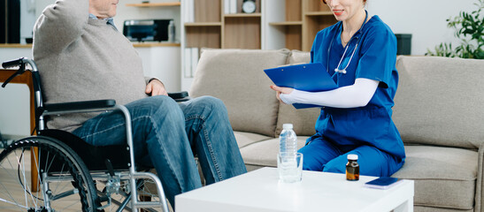 Nurse in blue scrubs reviews medication with an elderly patient at home, showcasing real people,...