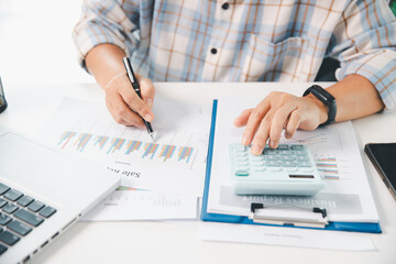 Accountant working on desk using calculator for calculate finance report in office. business...