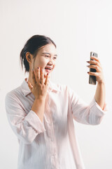 Asian woman rejoicing, looking happy, champion, fist pump gesture, standing over white background....