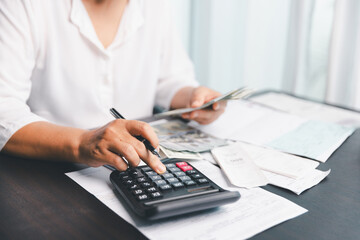 Using calculating machine, household carefully manages each bill and expense to plan financial...